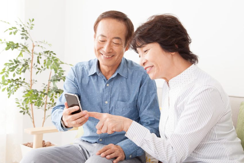 夫婦でスマートフォンをチェックする